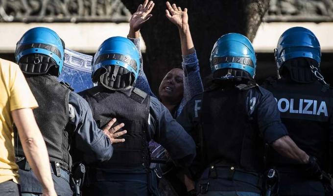 Il poliziotto e la migrante. Sprazzo di umanità nell’orrore di Piazza Indipendenza a Roma | FOTO