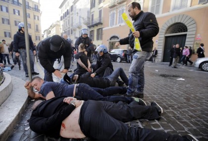 Feyenoord fans lie facedown on the street after being detained during clashes that broke out at the Spanish Steps prior to the start of the Europa League soccer match between Roma and Feyenoord in Rome